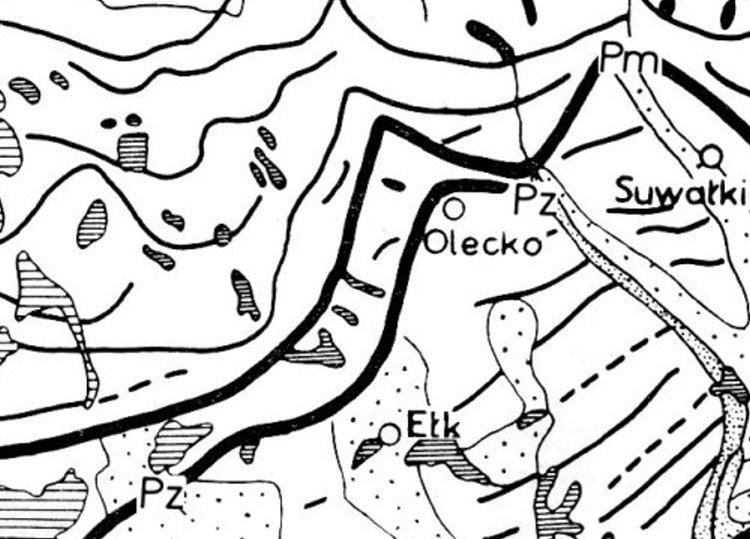 Czarno-biała mapa z zaznaczonymi miastami Olecko, Ełk i Suwałki oraz granicami i symbolami geologicznymi.