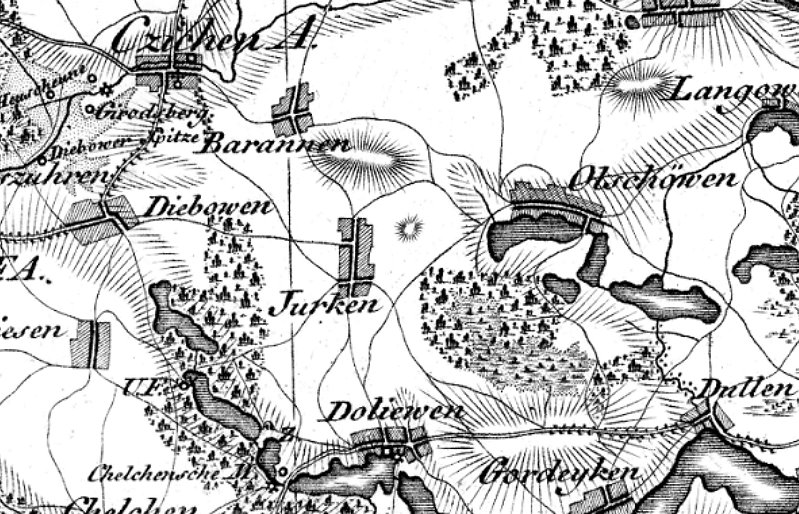 Stara mapa w czarno-białych barwach przedstawiająca tereny z wioskami, lasami, jeziorami i drogami. Widoczne są nazwy miejscowości, takie jak „Jurken”, „Barannen”, „Dolewen” i „Gordeyken”. Rysunki drzew symbolizują lasy, a linie wskazują drogi i granice terenu.