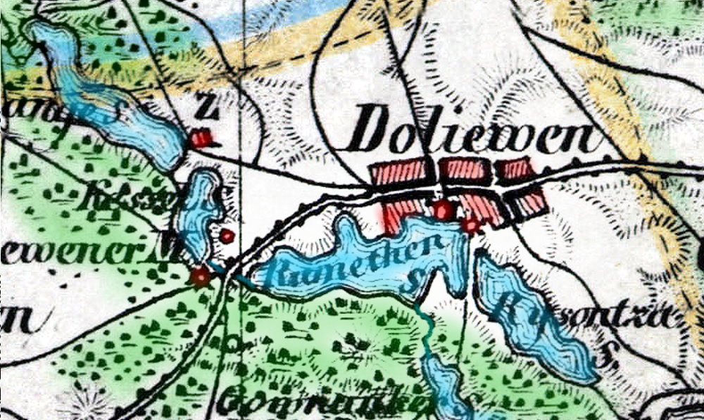 Kolorowa, stara mapa pokazująca wieś „Doliwen”, otoczoną jeziorami i lasami. Jeziora oznaczono na niebiesko, lasy na zielono, a budynki na czerwono. Przez środek miejscowości przebiega czarna linia – droga lub kolej. Widać nazwy miejsc, np. „Gownanker” i „Rysontza”.
