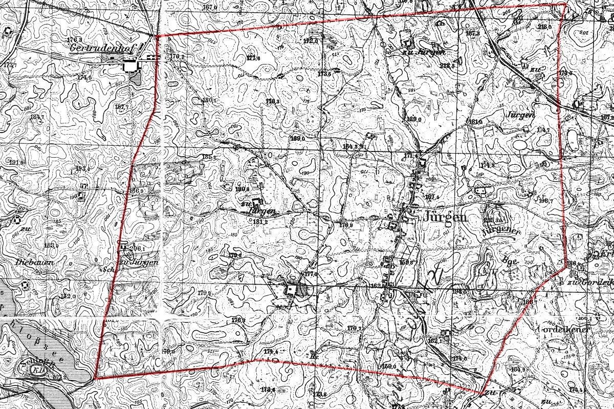 Czarno-biała, szczegółowa mapa topograficzna z czasów historycznych, przedstawiająca teren wokół miejscowości z nazwami niemieckimi, takimi jak „Jürgen” i „Gertrudenhof”. Mapa pokazuje ukształtowanie terenu liniami wysokości, oznaczenia budynków, dróg, lasów i pól. Czerwona linia otacza zaznaczony obszar, wyznaczając granice opisywanego terenu.